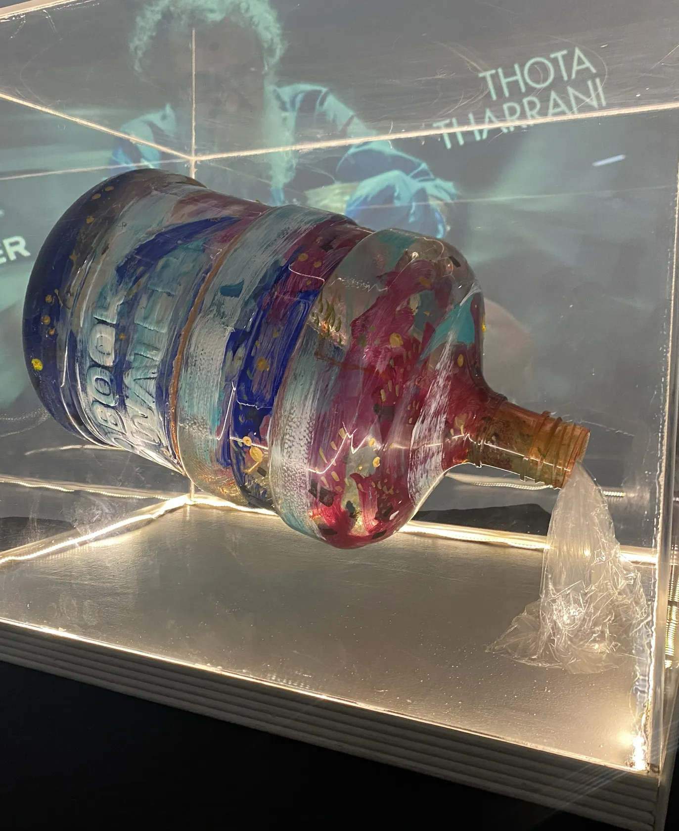 Thota Tharrani's painted artwork on a BookWater can, lit in a display case