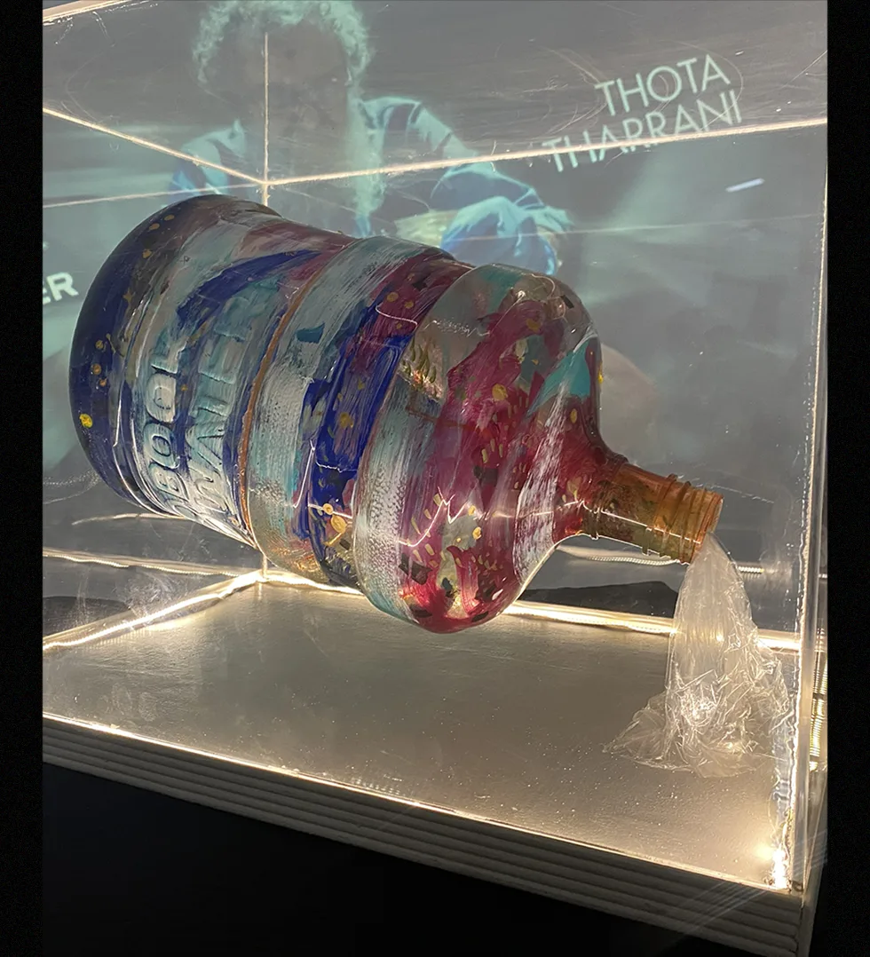 Thota Tharrani's painted artwork on a BookWater can, lit in a display case